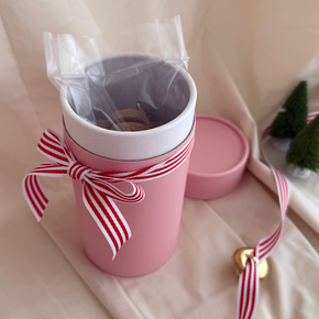 Celebrate the season with 12 bite-sized gingerbread cookies in charming festive shapes, perfectly nestled in our signature pink cylinder. Ready for gifting, these delightful treats are as beautiful as they are delicious—ideal for spreading holiday cheer to friends, family, or colleagues. Each cookie is crafted with care, perfectly spiced, and baked to golden perfection.